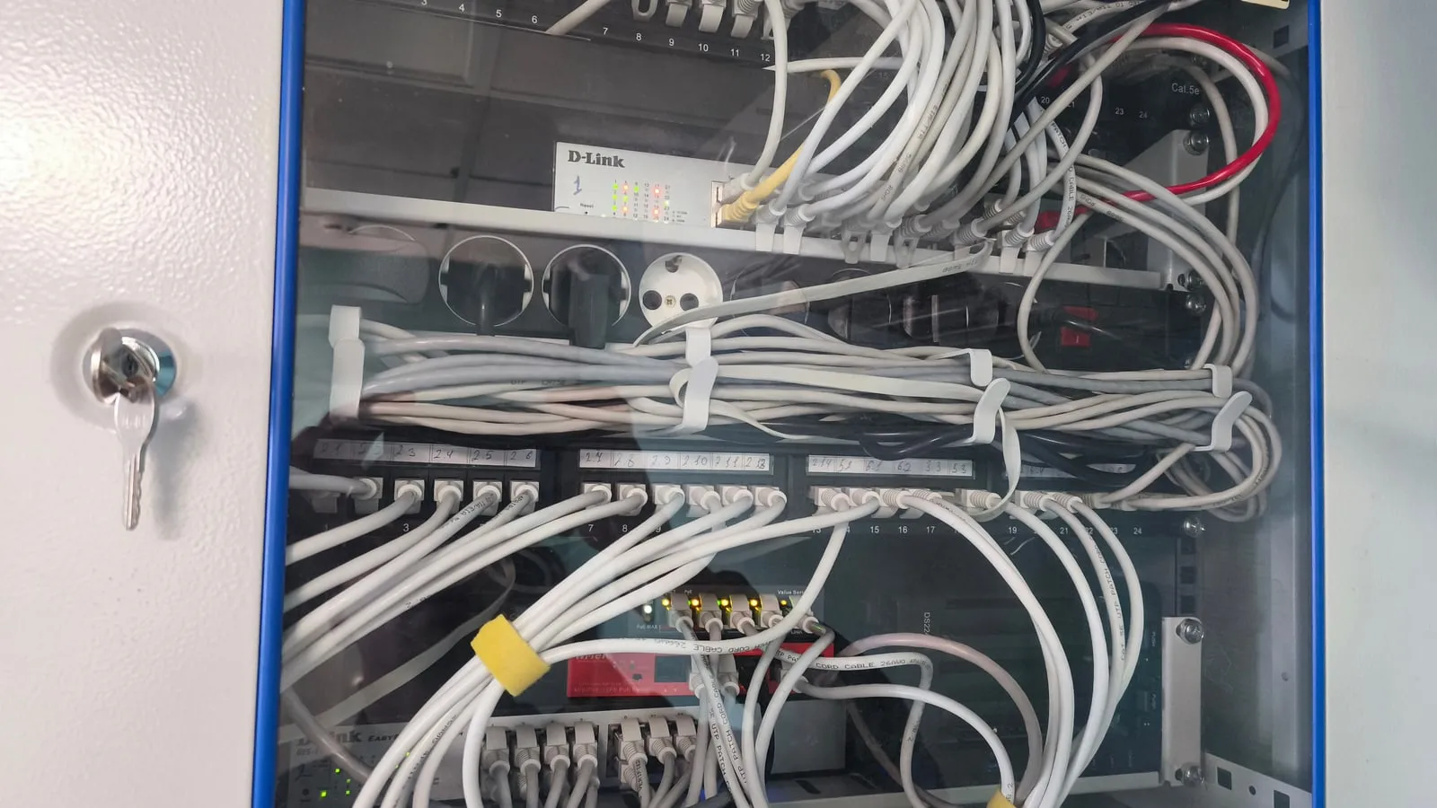 Открытый настенный телеком-шкаф офиса: PoE-коммутатор, патч-панель, видеорегистратор и оптический кросс
